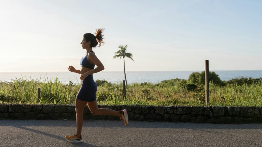 image of woman running outside. Is it best to run outdoors or on a treadmill?