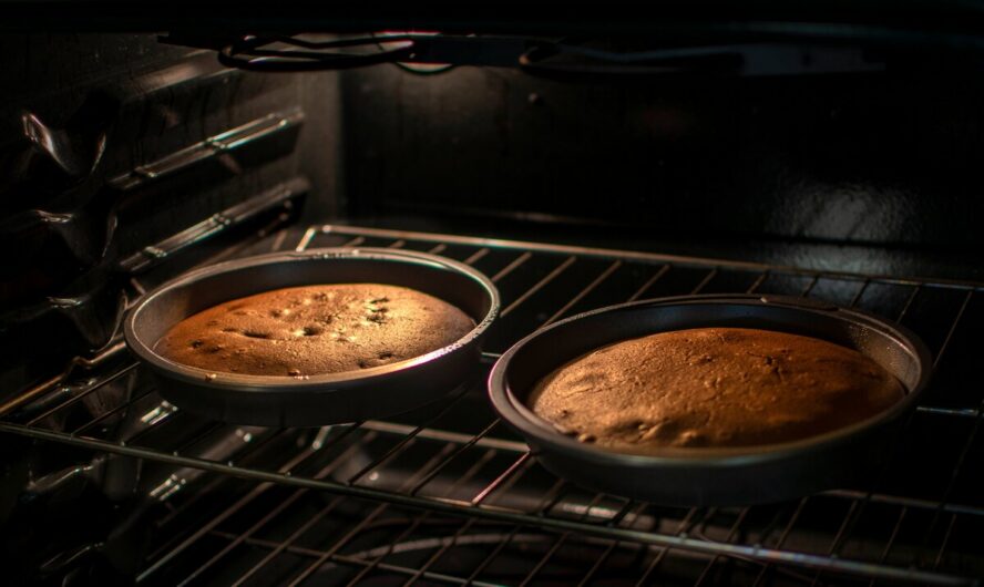 Image of two cheap cake pans filled with cake, on a rack in an oven.