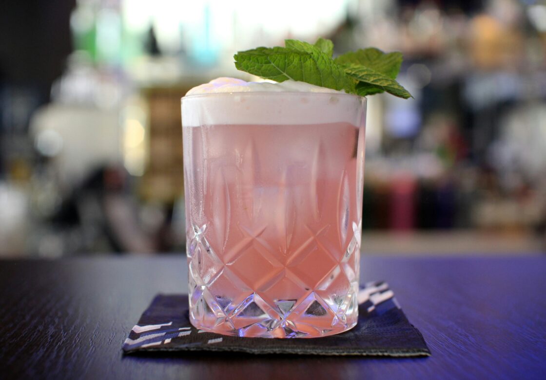 Image of a pink, creamy foamy drink cocktail