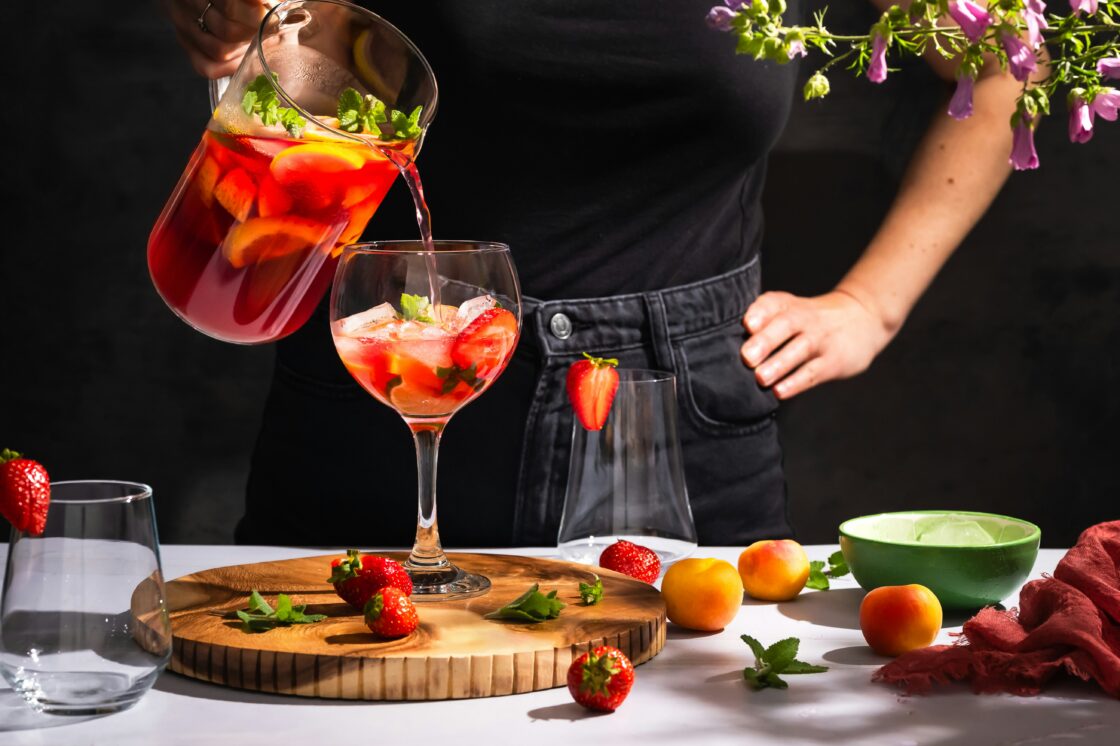 image of a pink sangria drink with berries and rose wine and rose geranium.