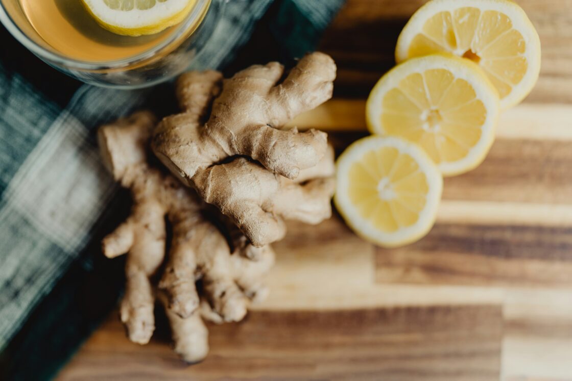 Image of ginger root and sliced lemon on a cutting board. Ginger is known to soothe your stomach as well as heartburn.