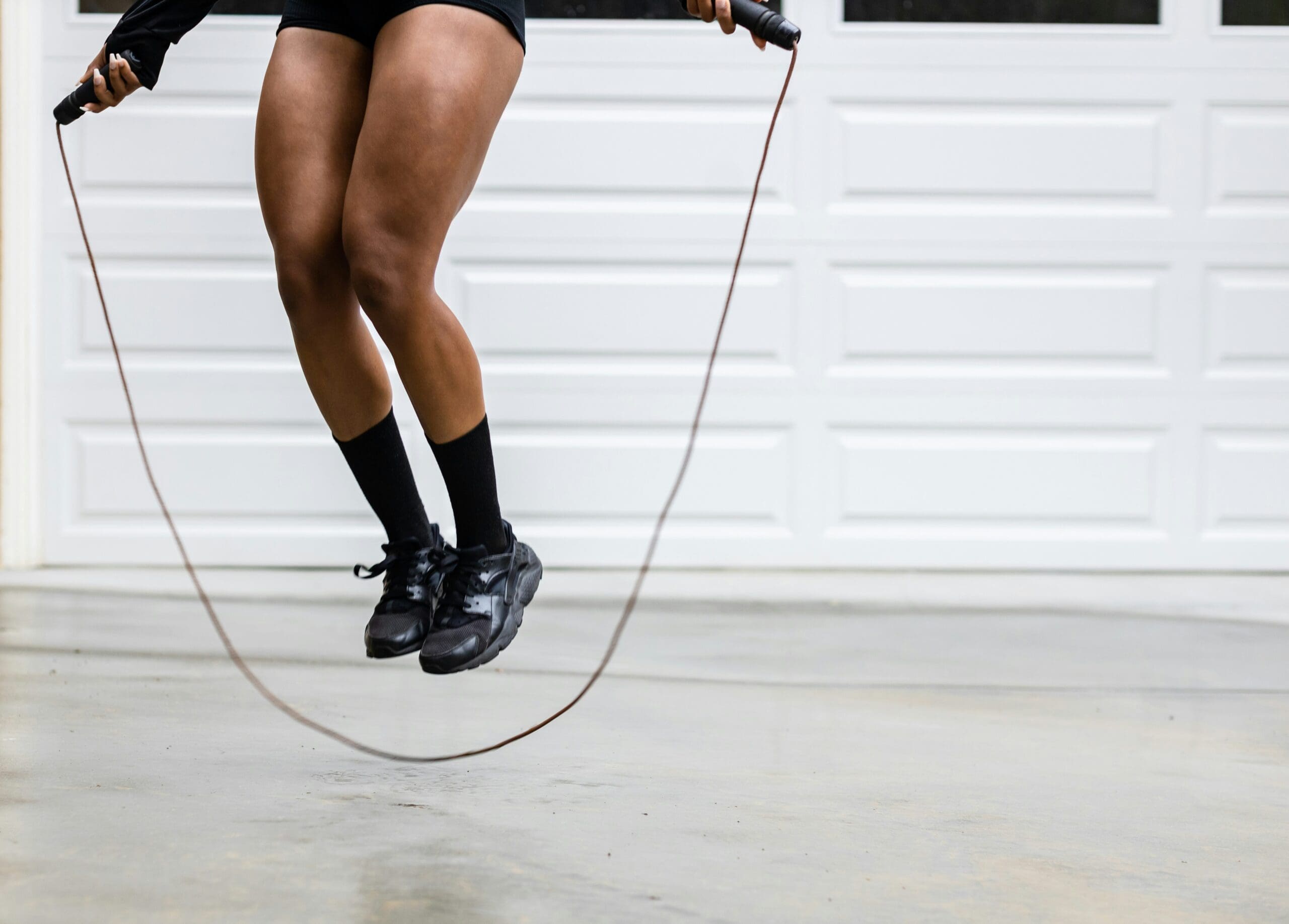 image of the bottom half of a woman mid-jump jumping rope. Did you know that jump rope racing.