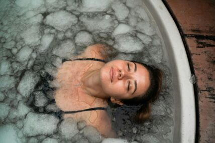 Image of a young woman with her eyes closed submerged in an ice bath.