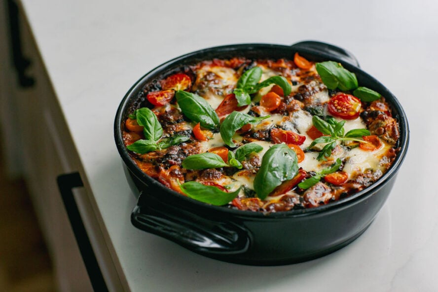 Image of an Xtrema pure ceramic non-toxic Versa pan filled with baked pasta, veggies and red sauce.