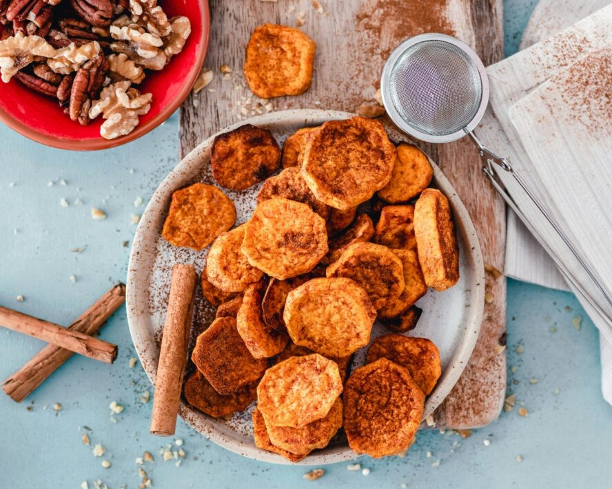 Image of a plate of sliced and roasted sweet potatoes dusted with cinnamon.