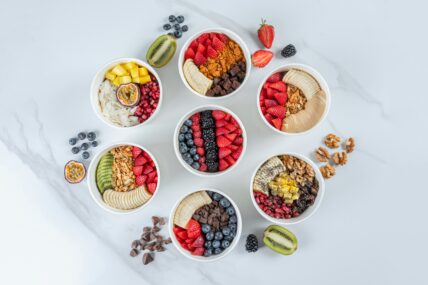 Image bowls filled with berries, nuts, and whole grains, which are on the list of foods for brain health.