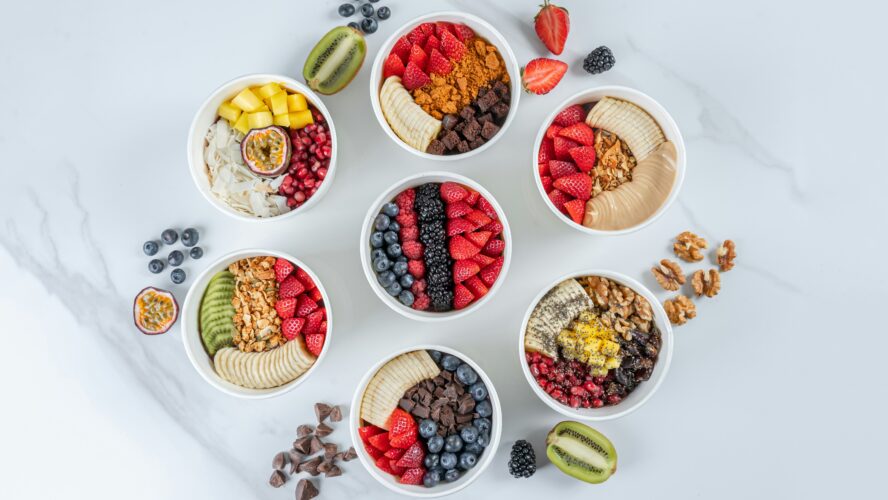 Image bowls filled with berries, nuts, and whole grains, which are on the list of foods for brain health.