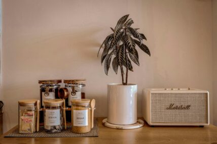Image of a kitchen counter with little glass jars of sugar, stevia, coffee, and creamer.