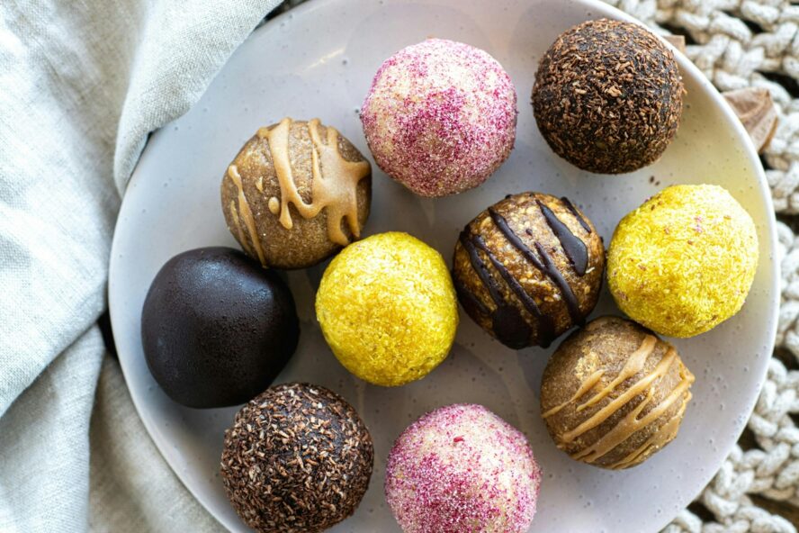 Image of a plate full of colorful energy balls featuring healthy dates and various other ingredients.
