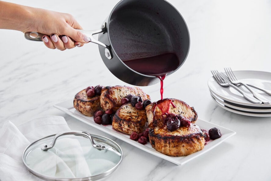 Image of the Valencia Pro 2-quart saucepan filled with a berry sauce, being poured over a plate of french toast.