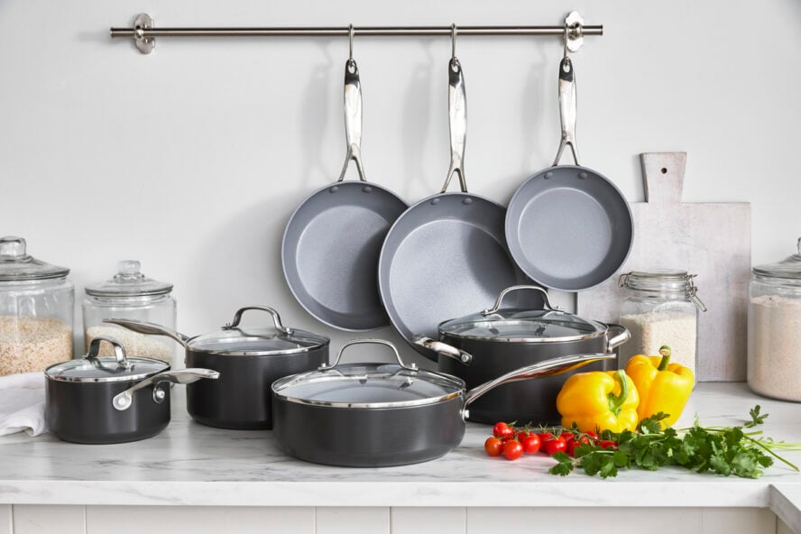 Image of the GreenPan Valencia Pro Ceramic Nonstick 11-piece set in a kitchen alongside some bell peppers, tomatoes, and cilantro.