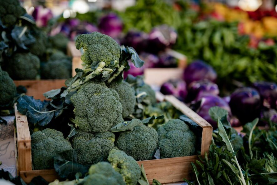 Image of piles of broccoli at the farmer's market on a table.