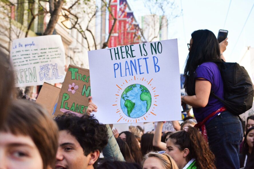 Image of a crowd at a protest, with someone holding a sign up that reads "There Is No Planet B".