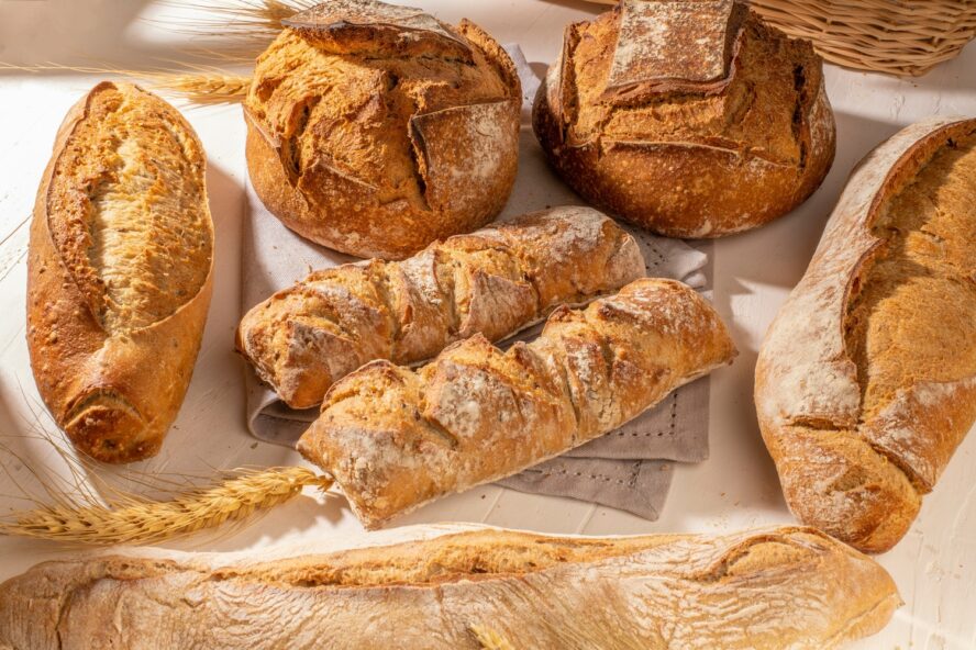 Image of a table covered in various European sourdough loaves in different shapes.