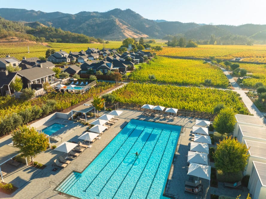 An overhead image of one of the pools at the Four Seasons Napa Valley and its surrounding residences and gorgeous mountains.