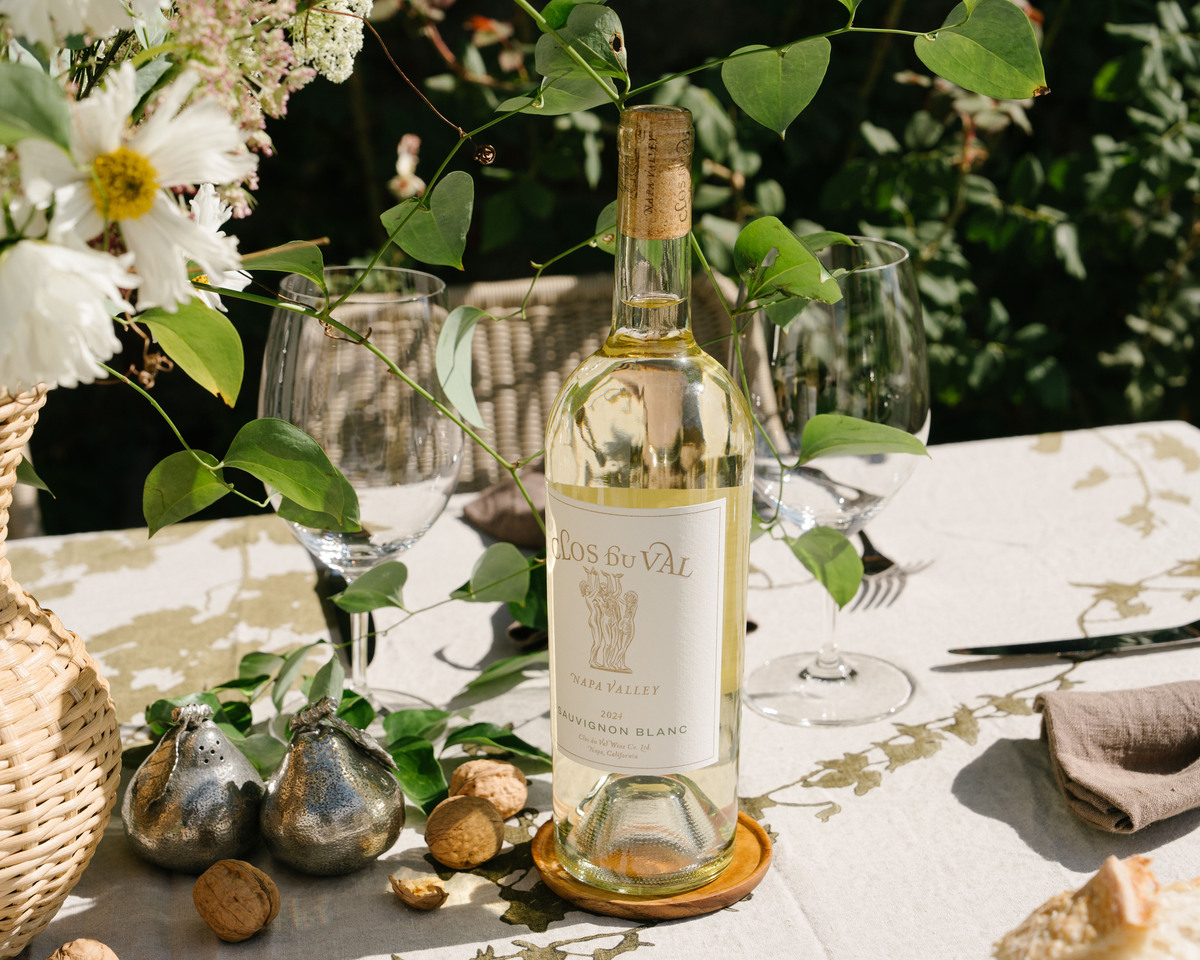 Image of a bottle of Clos du Val Sauvignon Blanc surrounded by a beautiful tablescape with white flowers.