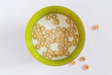 Image of a green bowl filled with Cheerios and milk, which may be contaminated with pesticides.
