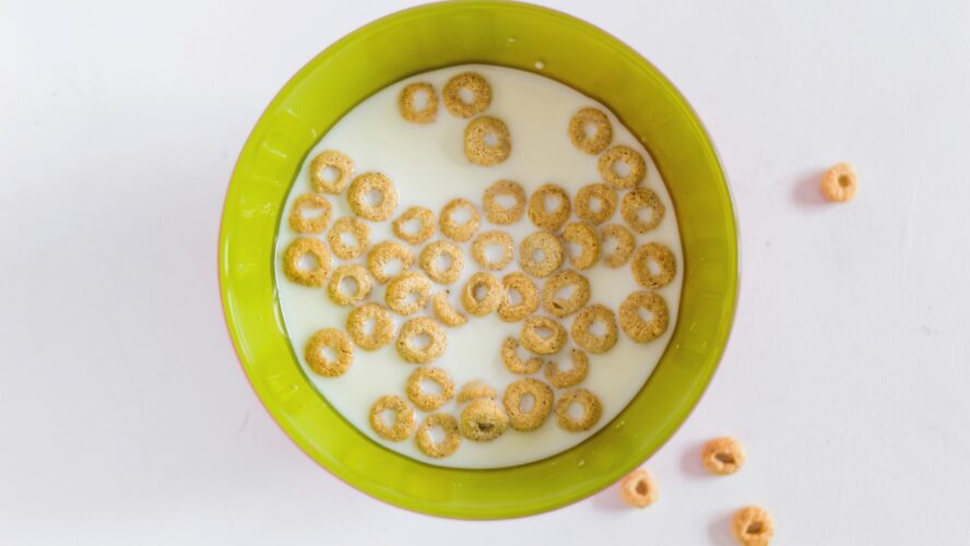 Image of a green bowl filled with Cheerios and milk, which may be contaminated with pesticides.