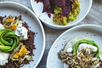Image of three plates of healthy, fiber-rich meals with avocado, corn, and grains.