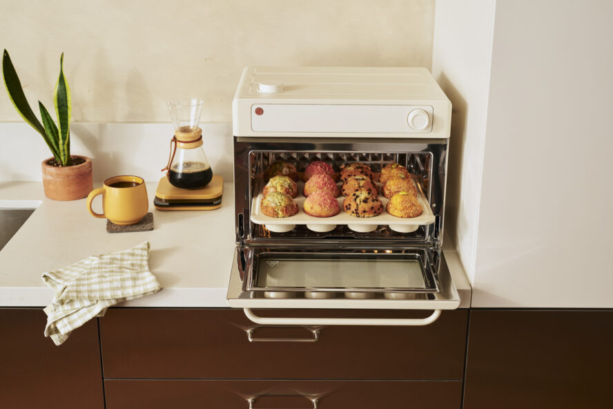 Image of the Our Place Wonder Oven Pro in the color Cream, being used to a bake a full tray of muffins.