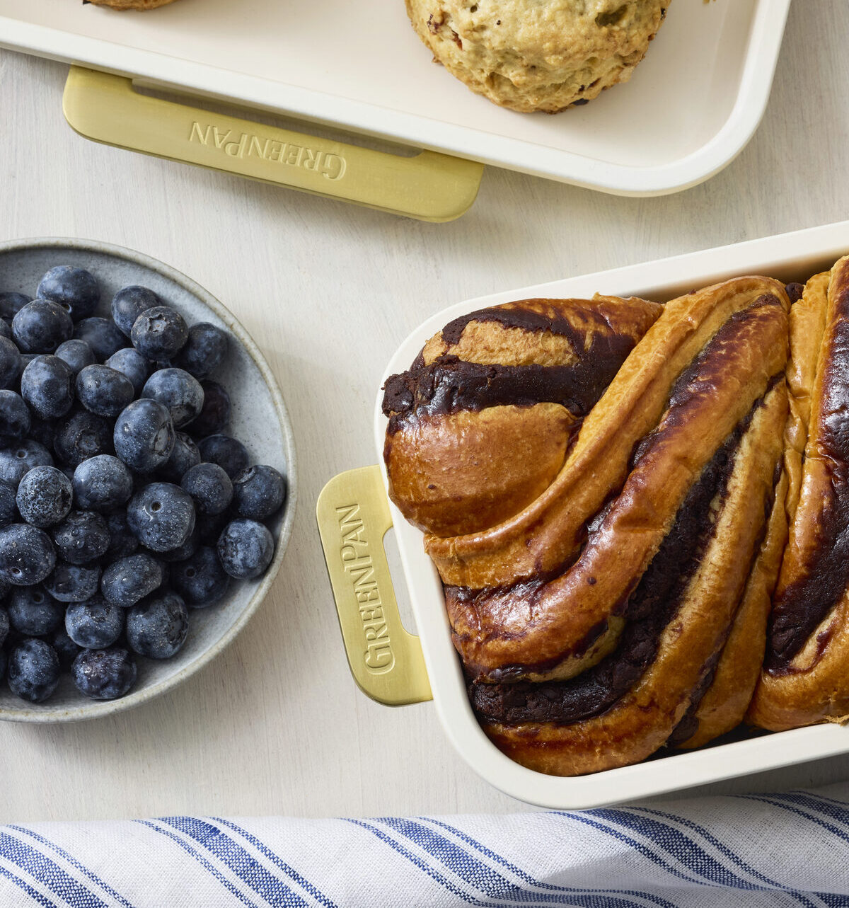 Close-up image of two GreenPan Reserve Bakeware pieces shown with a chocolate babka and scones.