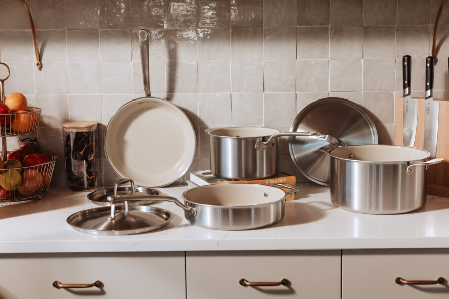 Image of the full Made In CeramiClad Cookware 7-piece set, displayed in a kitchen with white tile backsplash.