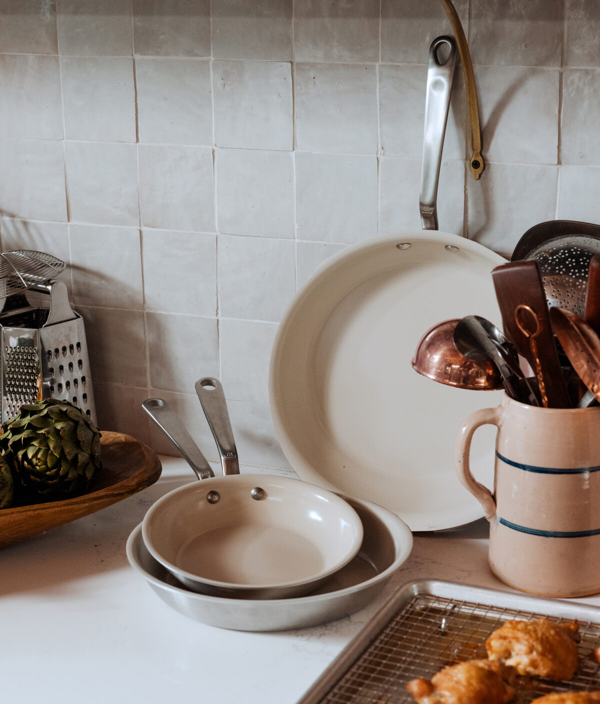 Image of a few Made In CeramiClad frying pans with cooking utensils.