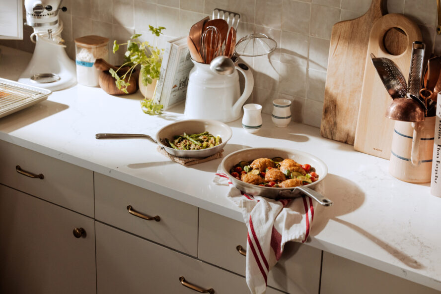Image of two Made In CeramiClad frying pans on a white kitchen countertop, featuring gorgeous holiday dishes.