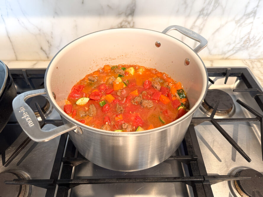 Image of the large Made In stock pot full of a hearty stock-based soup with vegetables.