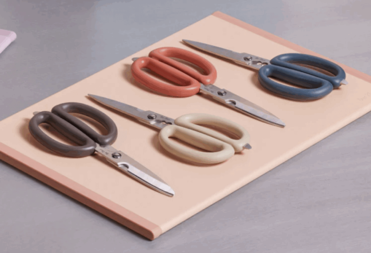 Image of the Our Place kitchen shears in multiple colors, arranged on a cutting board.