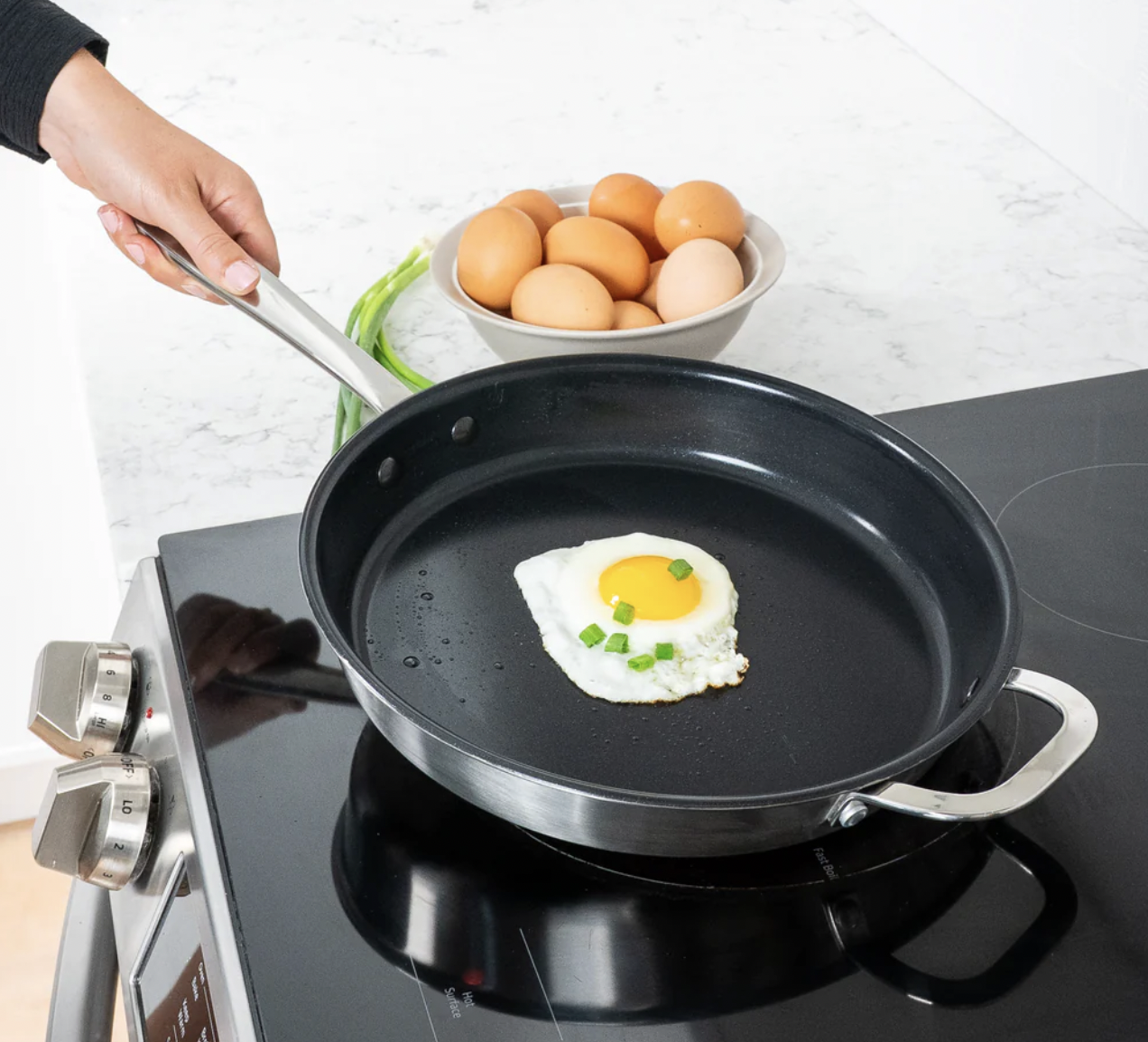 Image of the Alva Maestro Frying Pan in 5-Ply Stainless, Nonstick, with a fried egg being cooked over a stovetop.