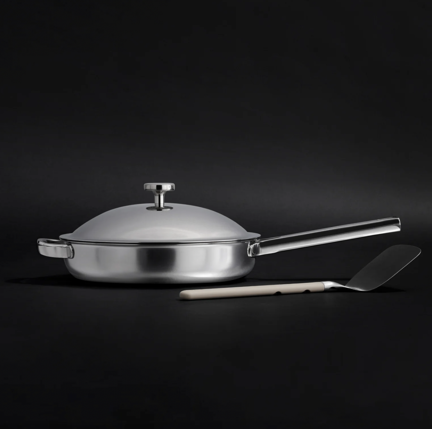 Image of the Our Place Titanium Always Pan Pro with lid, alongside the included stainless steel spatula.