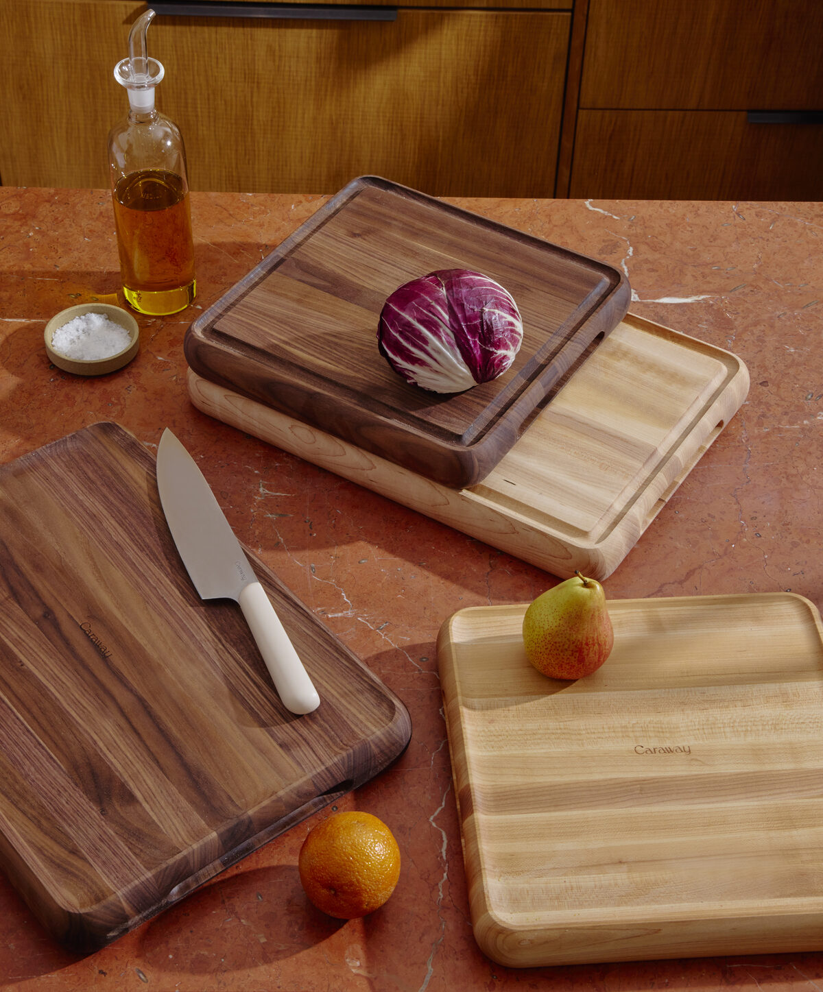 Image of several Caraway Butcher Blocks stacked on top of each other with some veg and a knife.