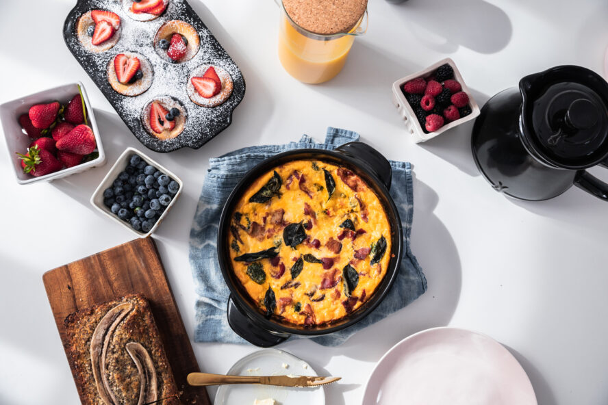 Image of several Xtrema pieces shown on a large table spread, being used to cook a frittata and breakfast muffins.