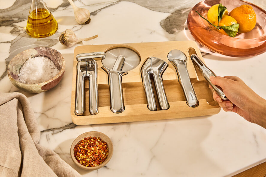 Image of the Caraway Kitchen Gadget Set in the included organizer shown on a beautiful marble countertop.