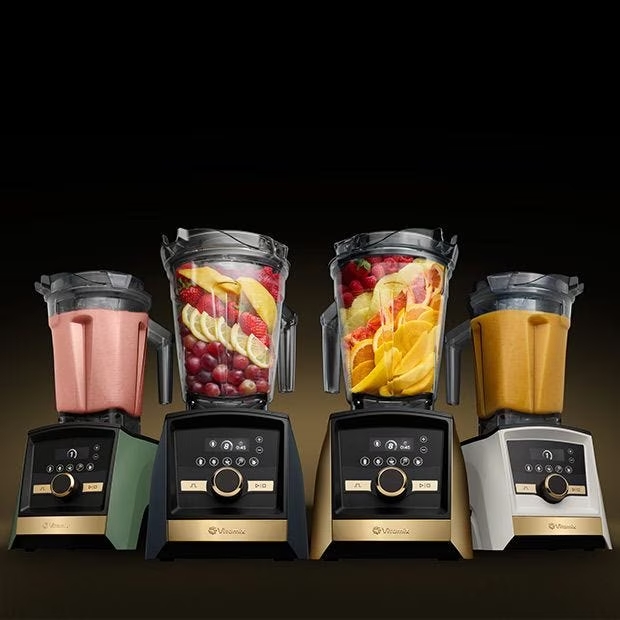 Image of four Vitamix Ascension A3500 blenders in a row with various fruits being blended.
