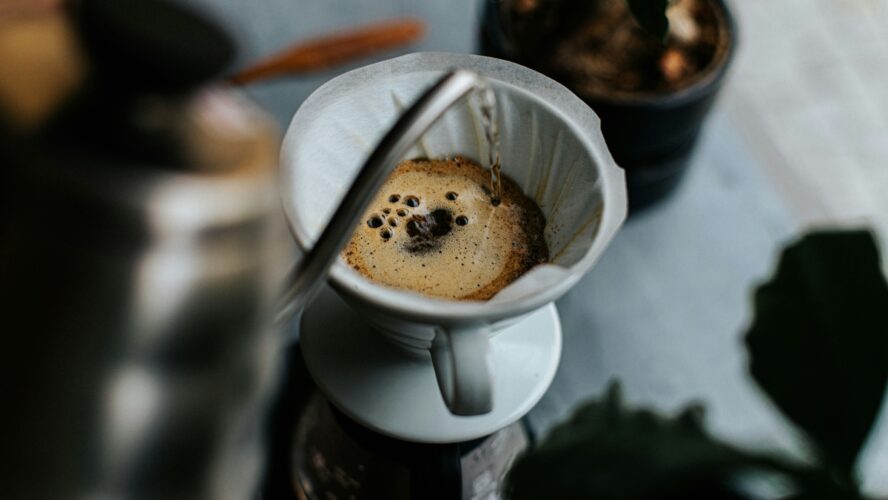 Image of a pour-over drip coffee method with hot water being poured into a filter.