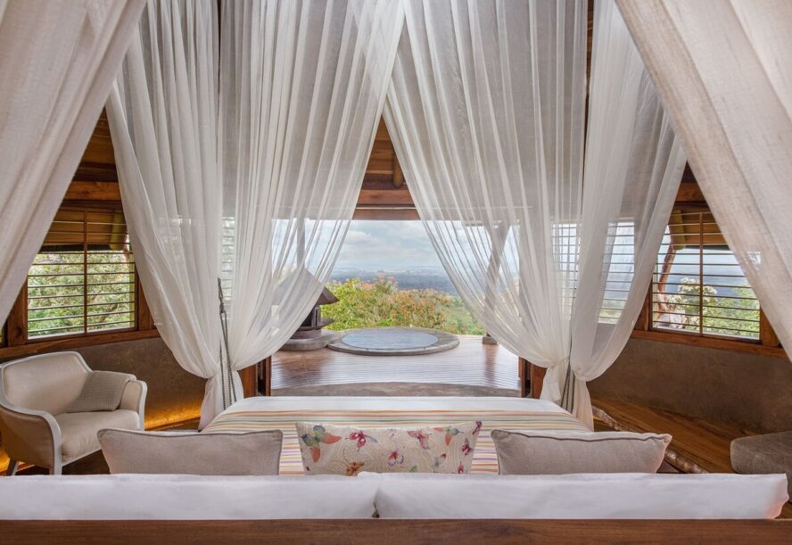 Image of a gorgeous canopy bed in a private luxury lodge, overlooking a small plunge pool and the Costa Rican jungle.