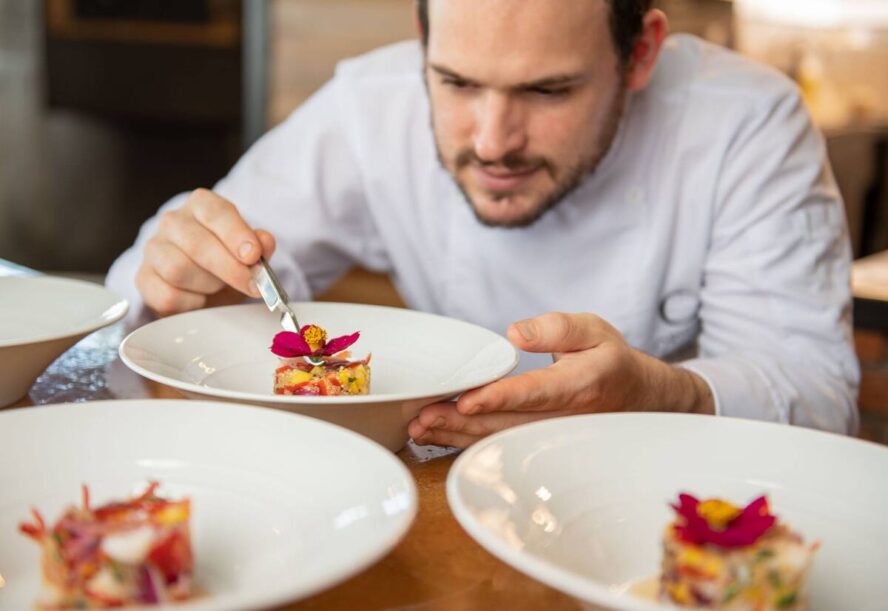 Image of a chef preparing dishes at El Salto Restaurant at Origins Floral Luxury Lodge.