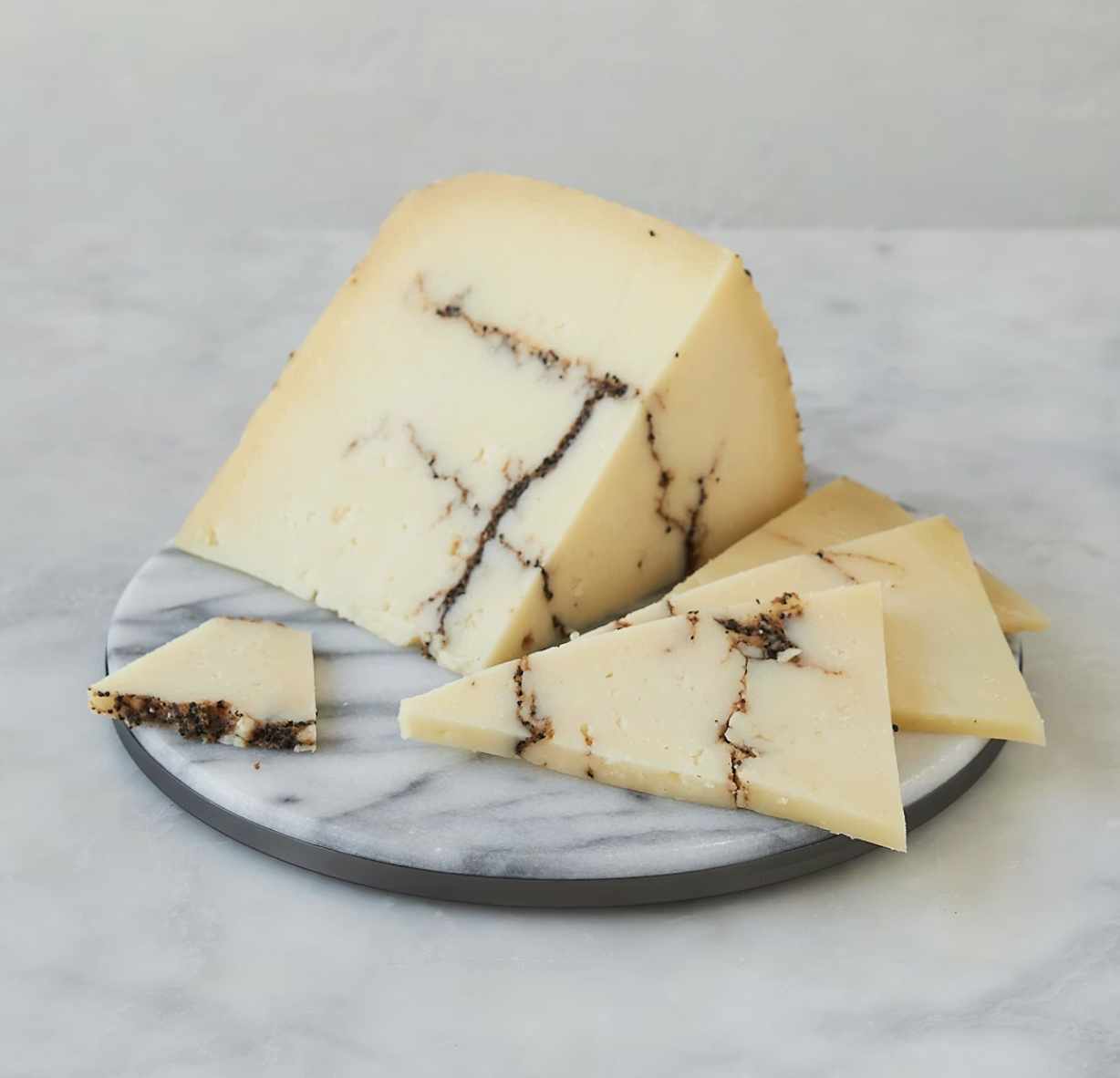 Image of a wedge of Moliterno al Tartufo cheese, featuring a blue vein of rich mushroom flavor.