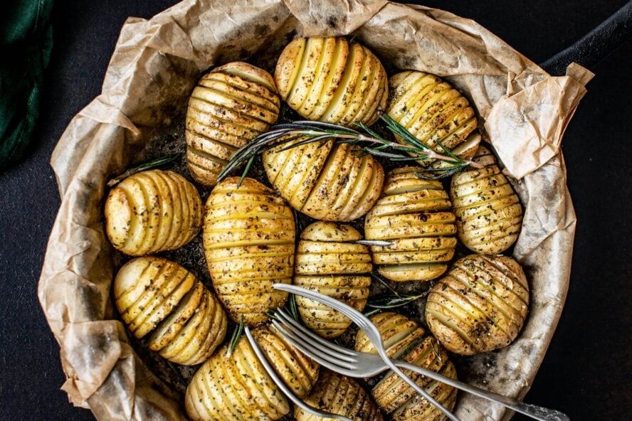Image of a large bowl of Yukon Gold potatoes sliced thinly and cooked with garlic, rosemary, and butter.