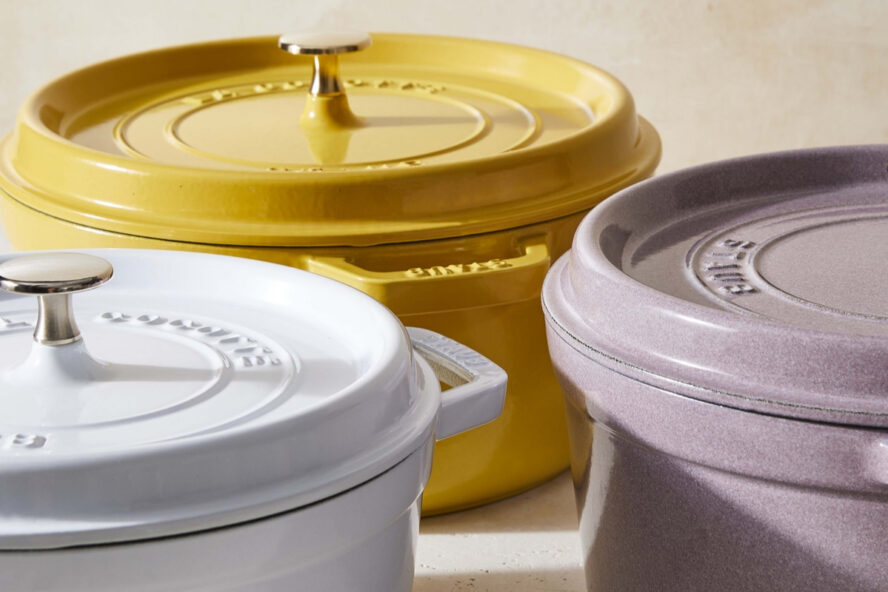 Image of three Staub round cast iron Dutch ovens in a soft white, yellow, and purple.