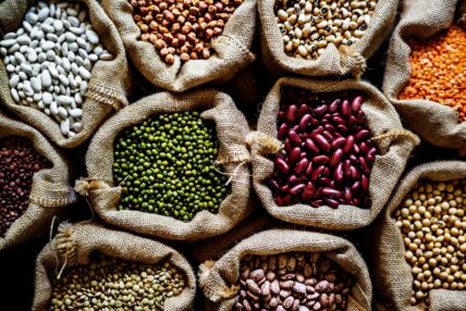 Image of several burlap sacks full of colorful varieties of beans.