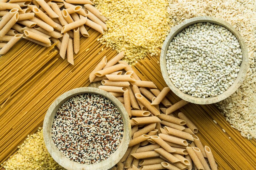 Image of a spread of different whole grain pastas, noodles, and rice arranged in a pleasing way.