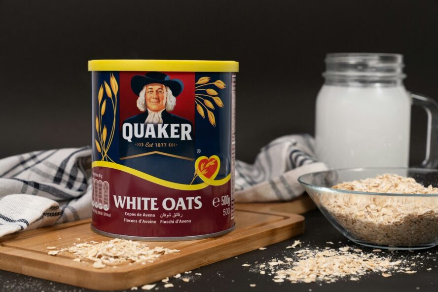 Image of a tin of Quaker instant oats sitting on a wooden cutting board.