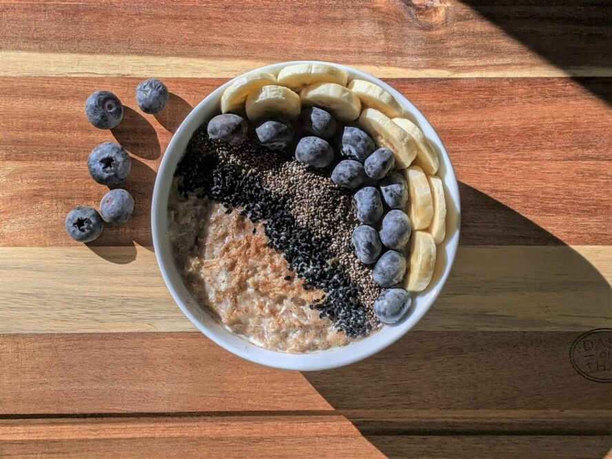 Image of a bowl of oatmeal topped with cinnamon, chia seeds, blueberries, and banana slices.