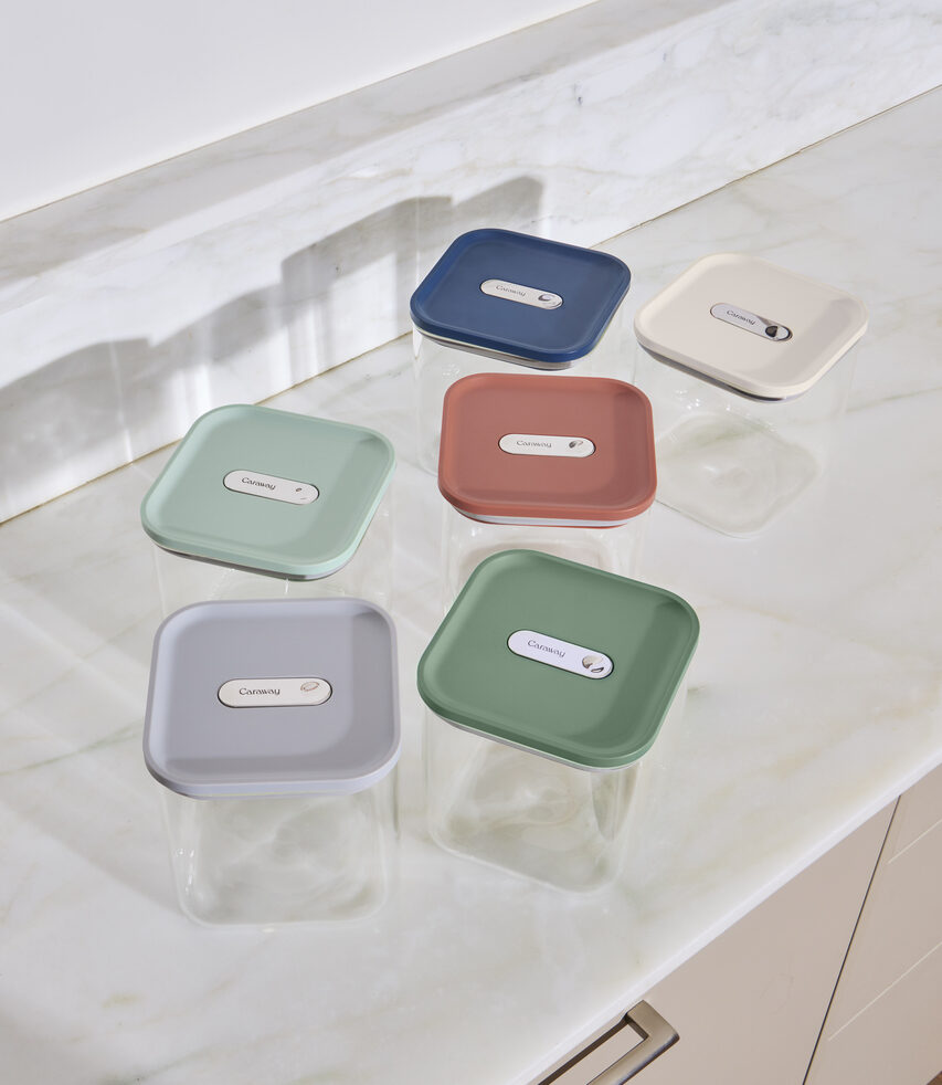 Image of several empty Caraway Glass Airtight Containers sitting on a marble countertop.