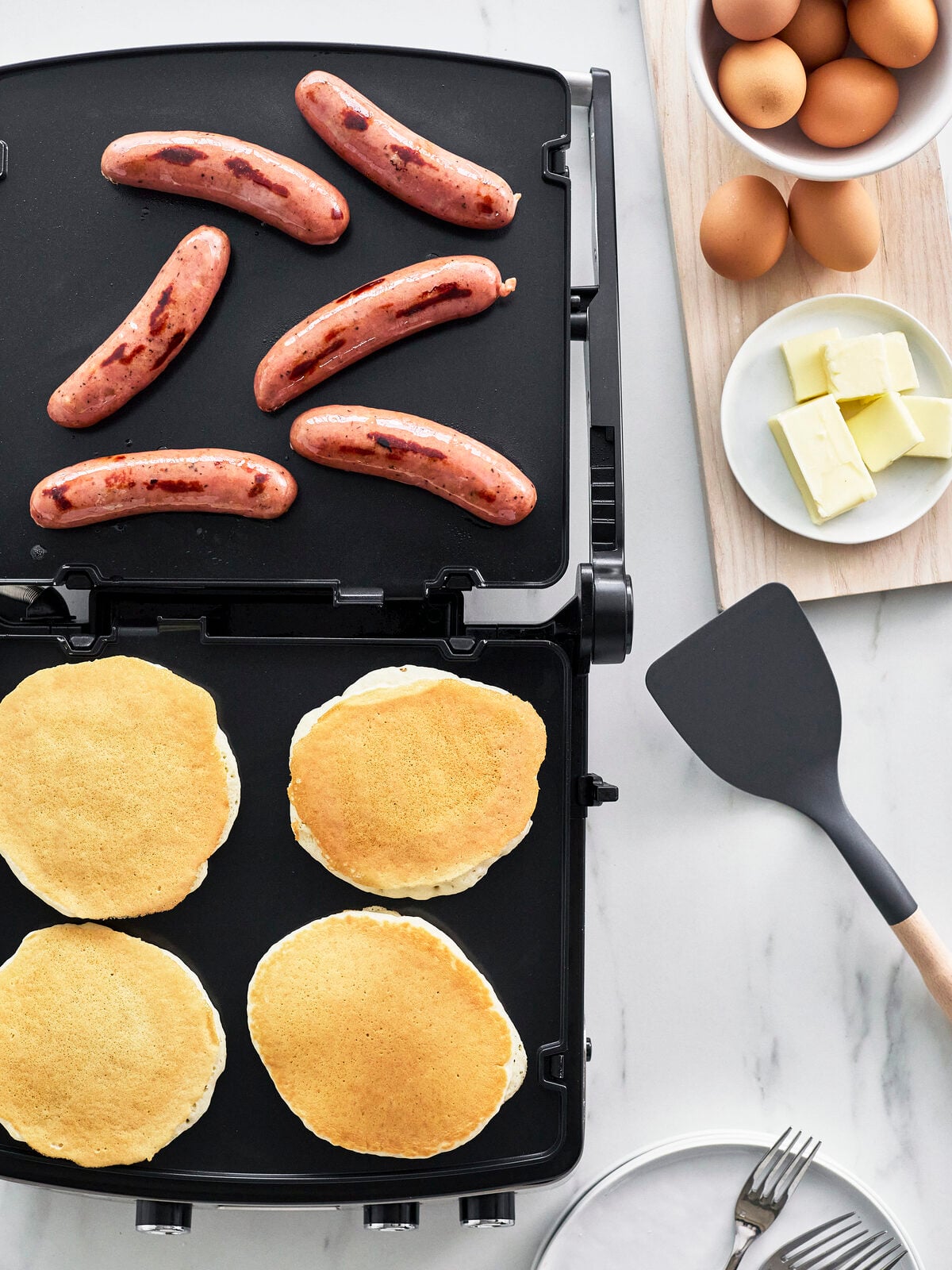 Image of the GreenPan Elite Multi Grill & Griddle with the appliance opened wide to use both of the dual heat zones for pancakes and sausages.