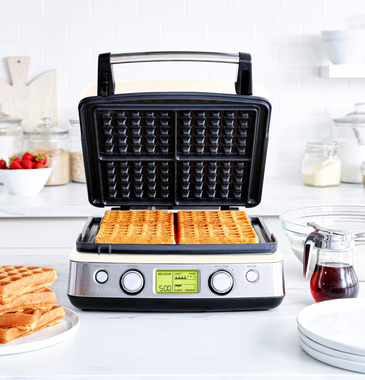 Image of the GreenPan Elite Ceramic Nonstick 4-Square Waffle Maker in Cloud Cream, shown with four waffles inside the appliance.