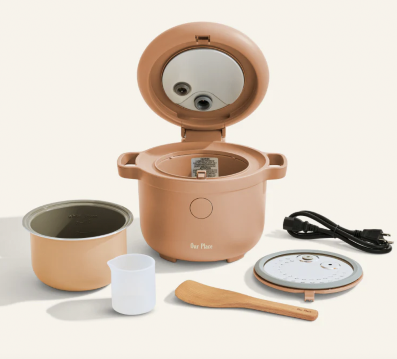 Image of the Our Place Rice Cooker in Spice with all the included accessories shown around it.